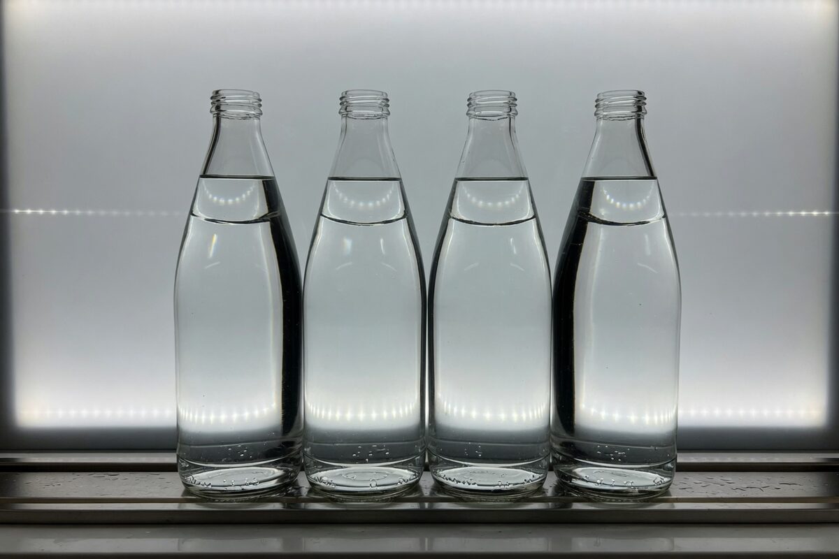 One bottle neck against a gray backlight, filled to a single line