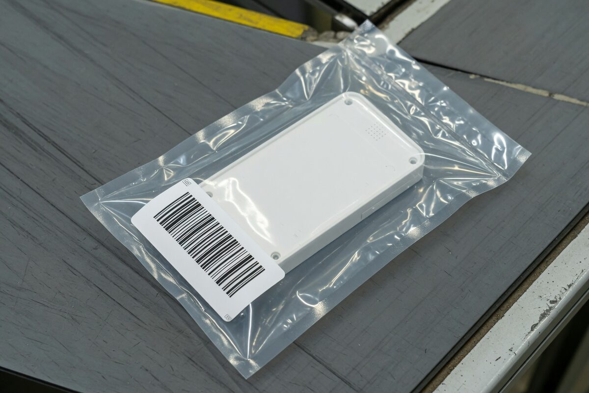 A device in a clear pouch with a barcode of separate bars beside it