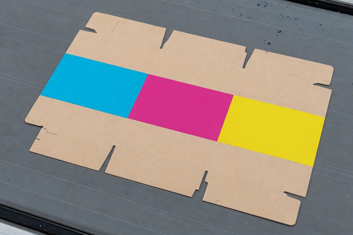 A brown carton with cyan, yellow, and magenta blocks meeting in one band